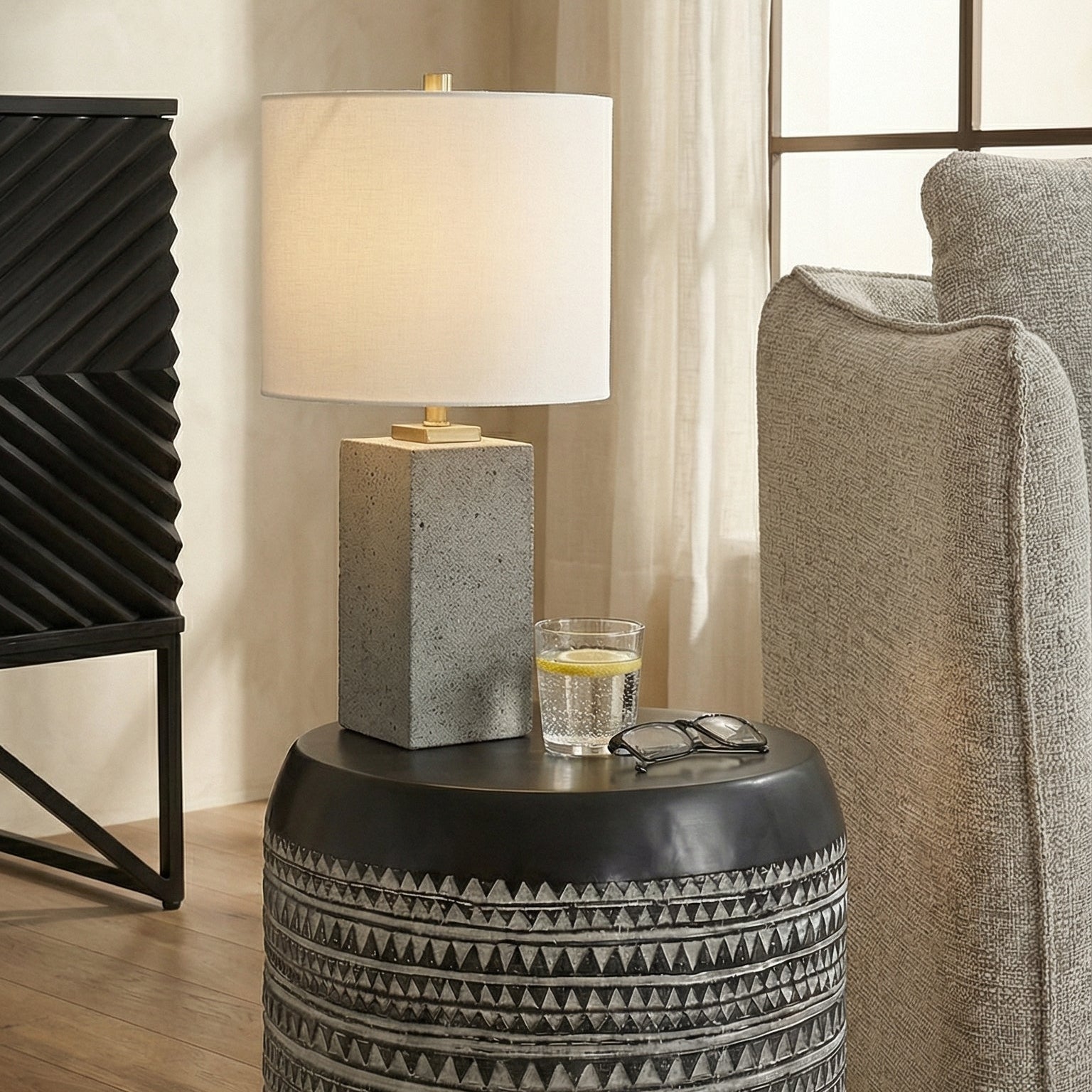 Patterned side table with lamp and glass in a living room setting
