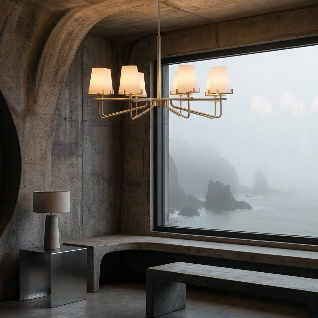 Modern interior with a chandelier, table lamp, and large window overlooking a foggy landscape.