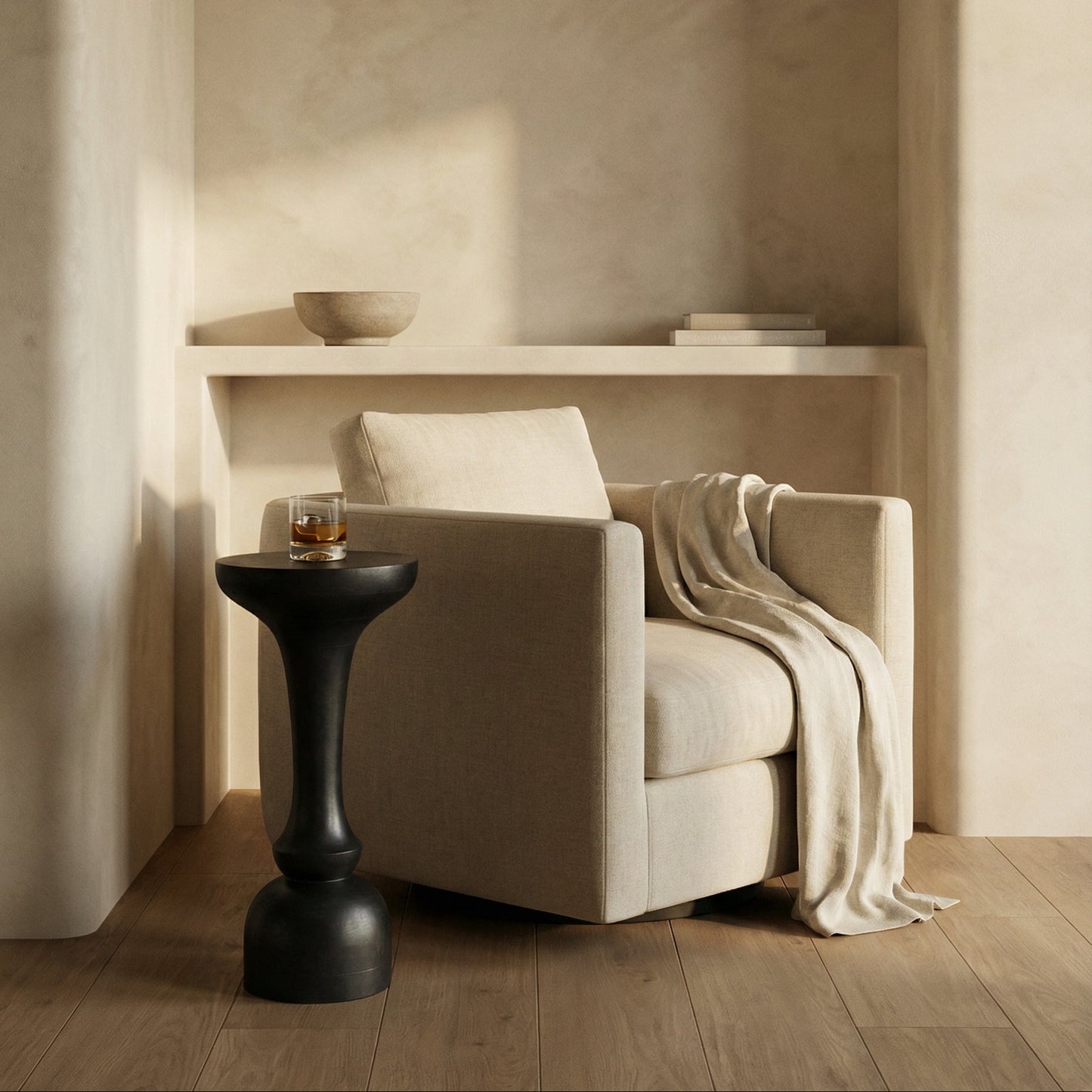 Beige armchair with a blanket and a small black table in a softly lit room.