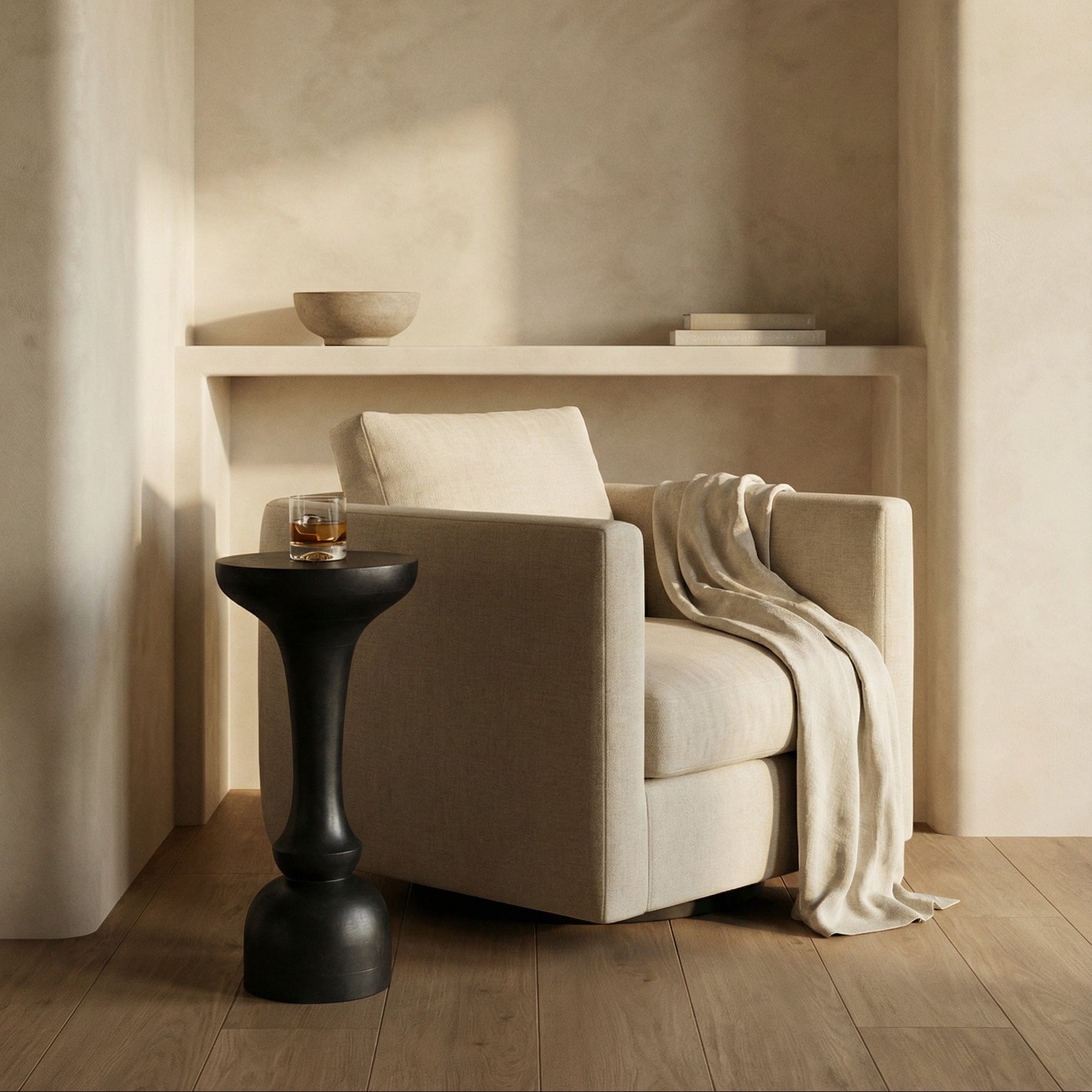 Beige armchair with a blanket and a small black table in a softly lit room.