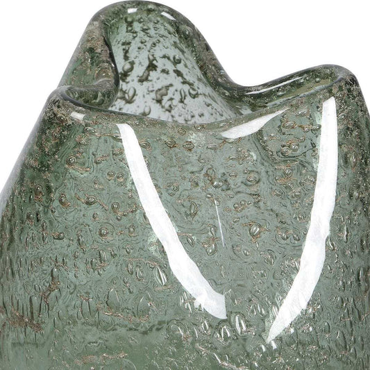 Two green glass vases on a wooden surface with one containing white flowers.