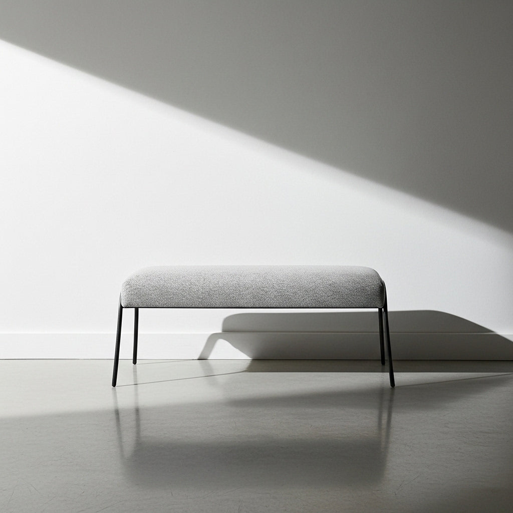 Gray bench against a white wall with soft shadows