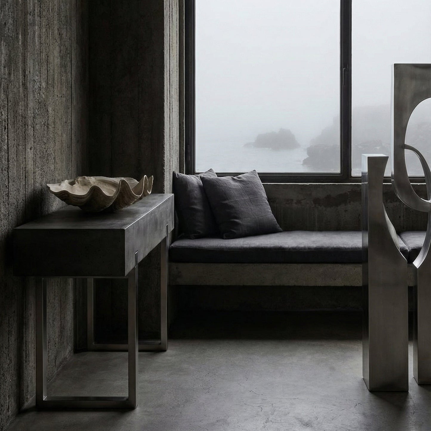 Modern interior with concrete walls, a large window, and minimal furniture.