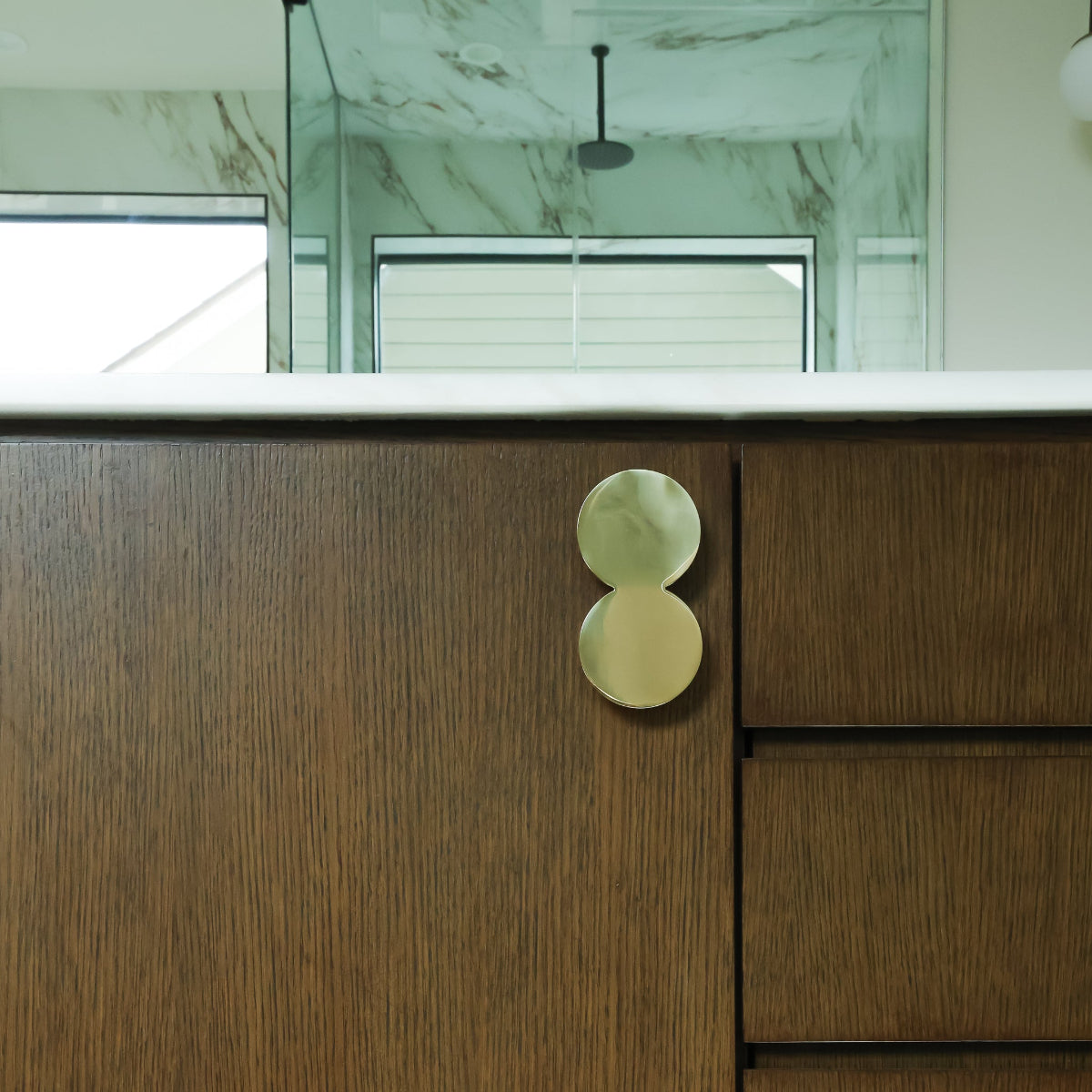 Oversized Unlacquered Polished Brass on Bathroom Cabinet Doors in Luxury Marble Bathroom.