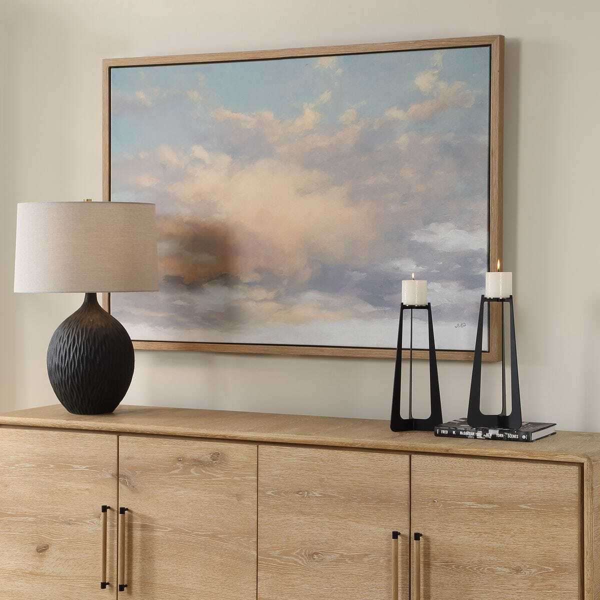 Wooden sideboard with decorative items and a large framed painting on the wall.