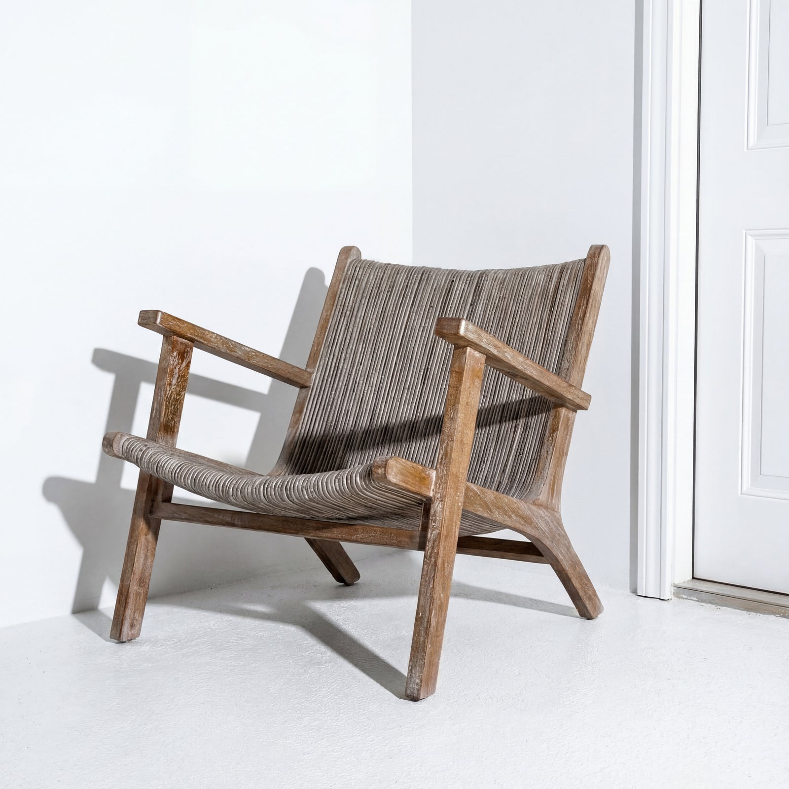 Wooden armchair with woven backrest on a white floor and wall