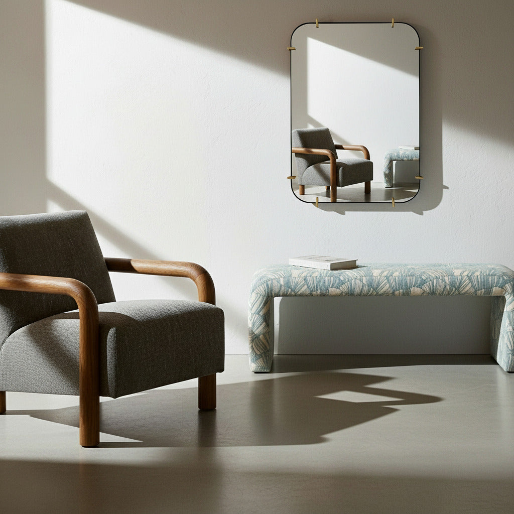 Modern living room with a gray armchair, patterned coastal upholstered bench, and rectangular mirror.