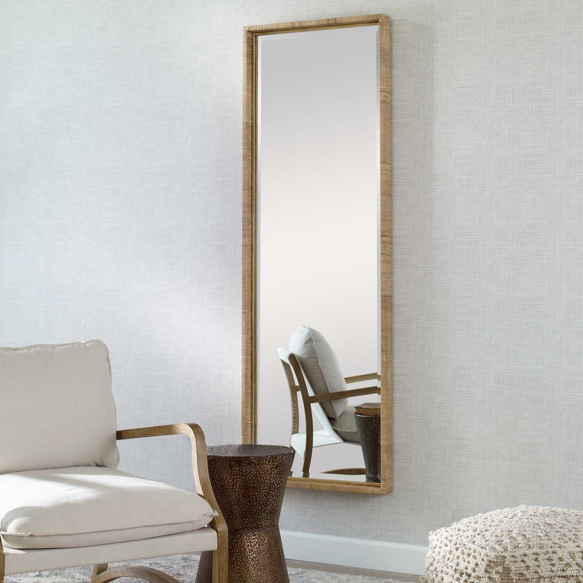 Corner of coastal full length mirror in rattan and white armchair.