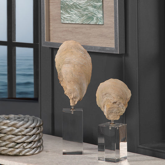 Two shell cultures on console table with a view to the ocean out the window and a framed piece of ocean art above that is sketched in green pencil.