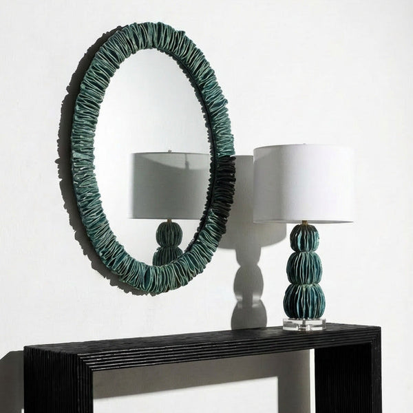Modern console table with round mirror and decorative lamps on a white background