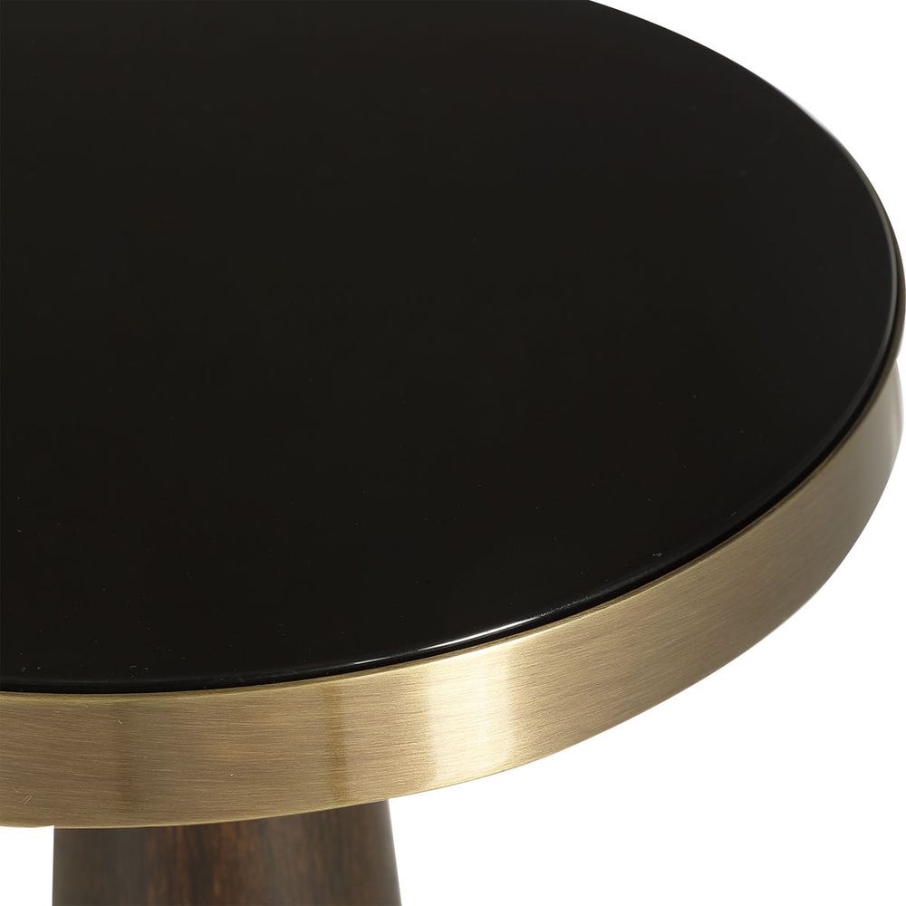 Round table with black mirrored surface and gold base on a white background