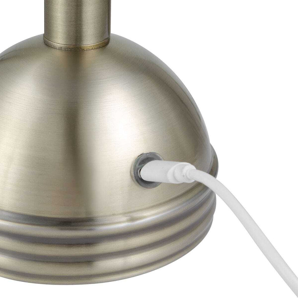 Close-up of a metallic pendant light with a white USB-C cord on a white background
