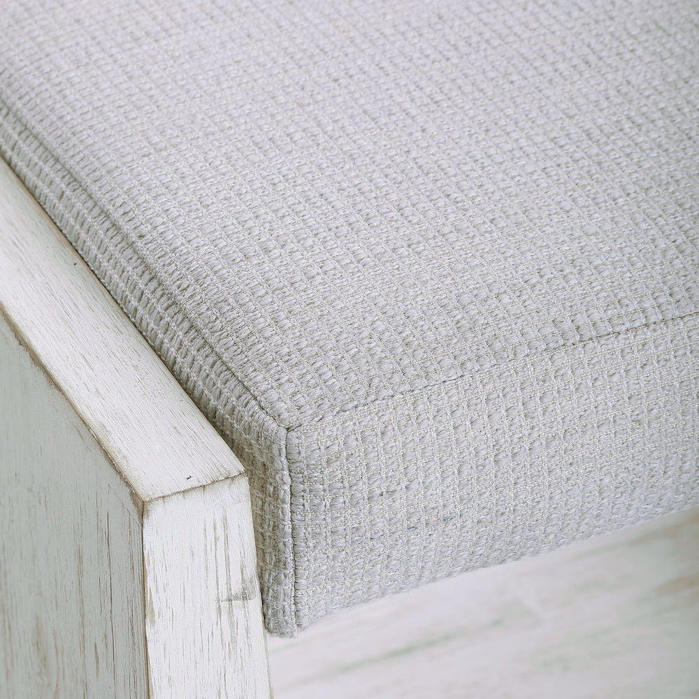 Small white bench with fabric.