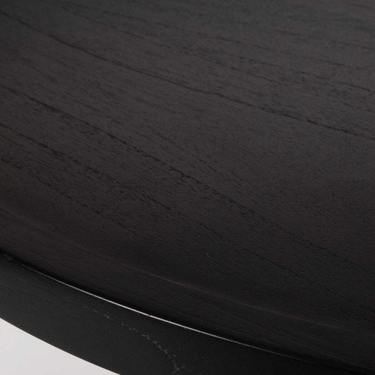 Black round dining table with unique base design on a white background