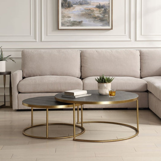 Set of two dark gray shagreen and brass nesting coffee tables in a modern living room.