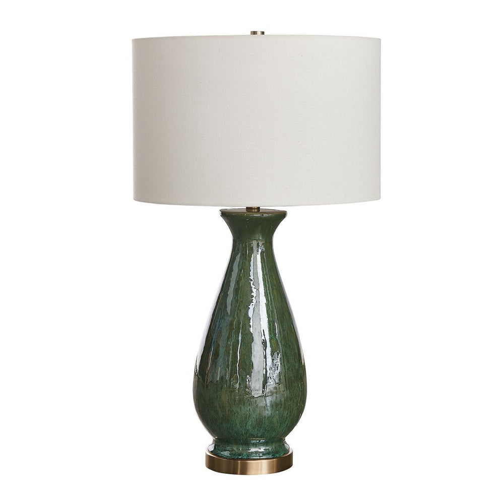 Green ceramic table lamp with a white shade on a white background