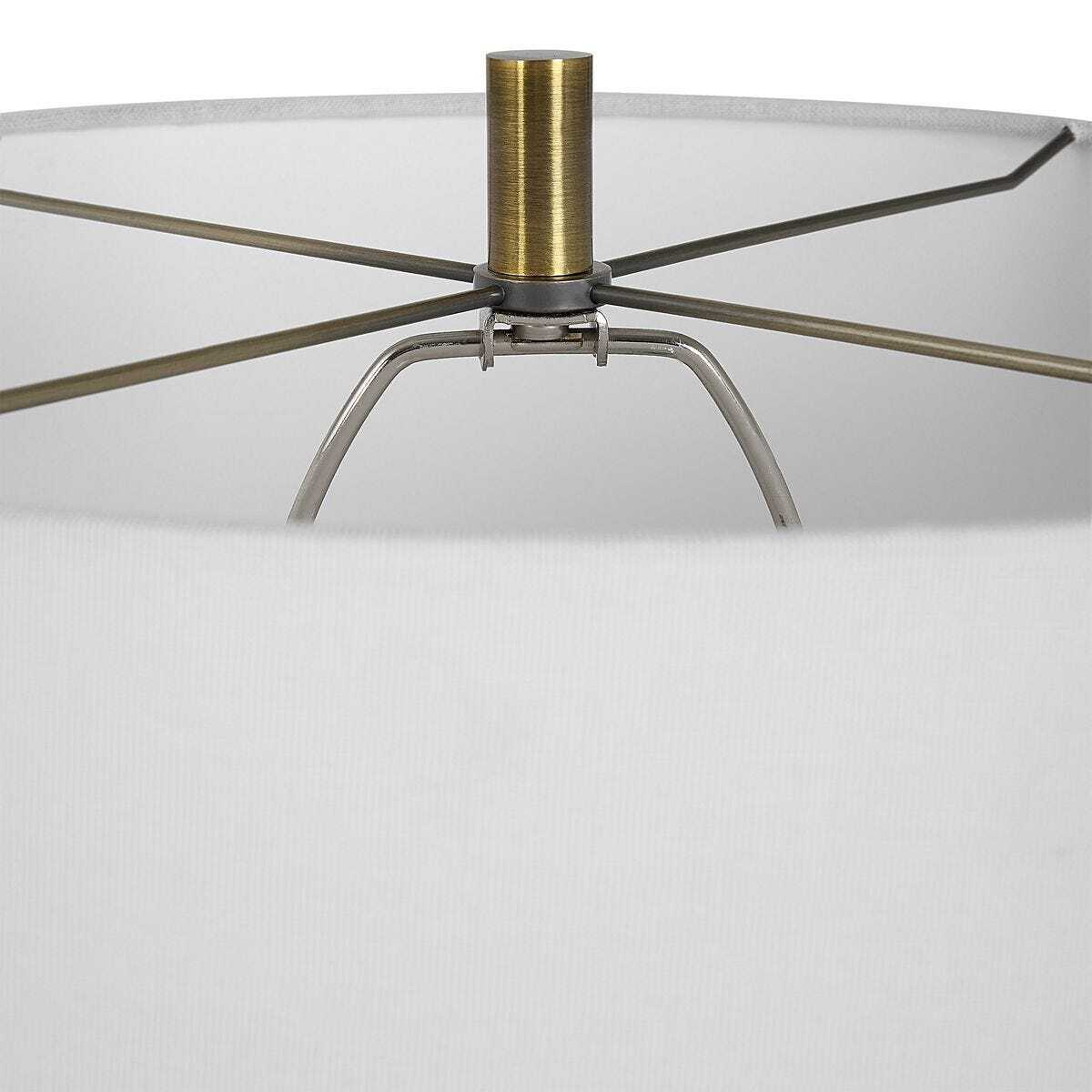 Close-up of a lamp with a metallic base and clear glass shade on a white background