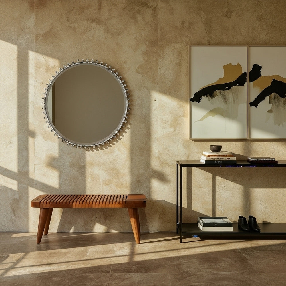 Round mirror on a textured wall with a wooden bench and console table below.