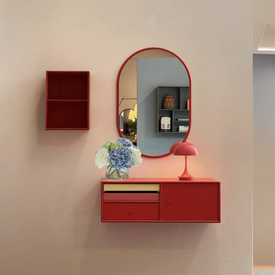 Fake hydrangeas on a floating red shelf with a red lamp and a red mirror.