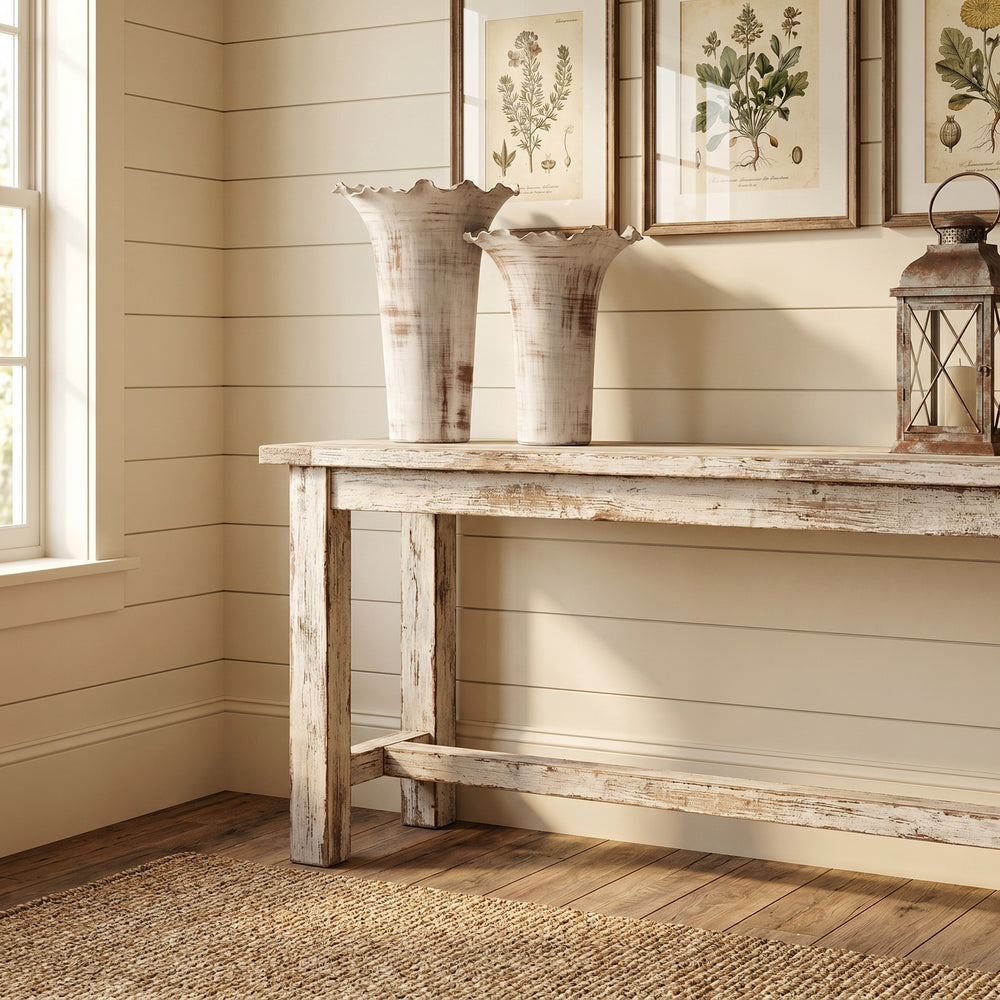 Wooden table with decorative items against a wall with framed pictures.