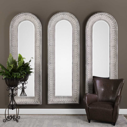 Arched mirror with decorative silver frame on a white background