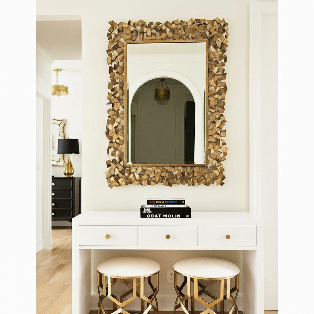 Decorative mirror with wooden frame above a white console table with drawers and stools.