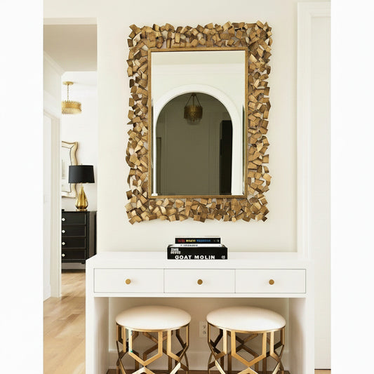 Decorative gold mirror with intricate frame design on a white background