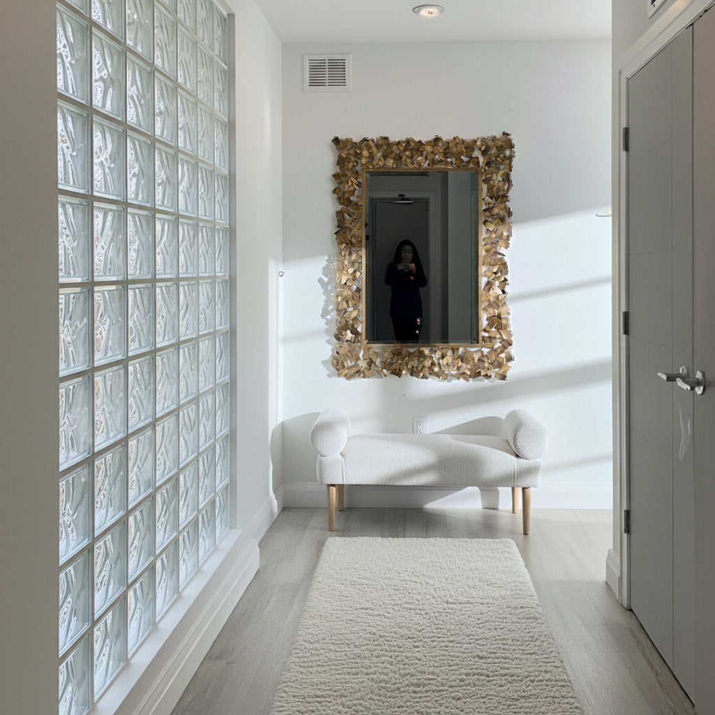 Modern interior with a textured wall, mirror, and white sofa.