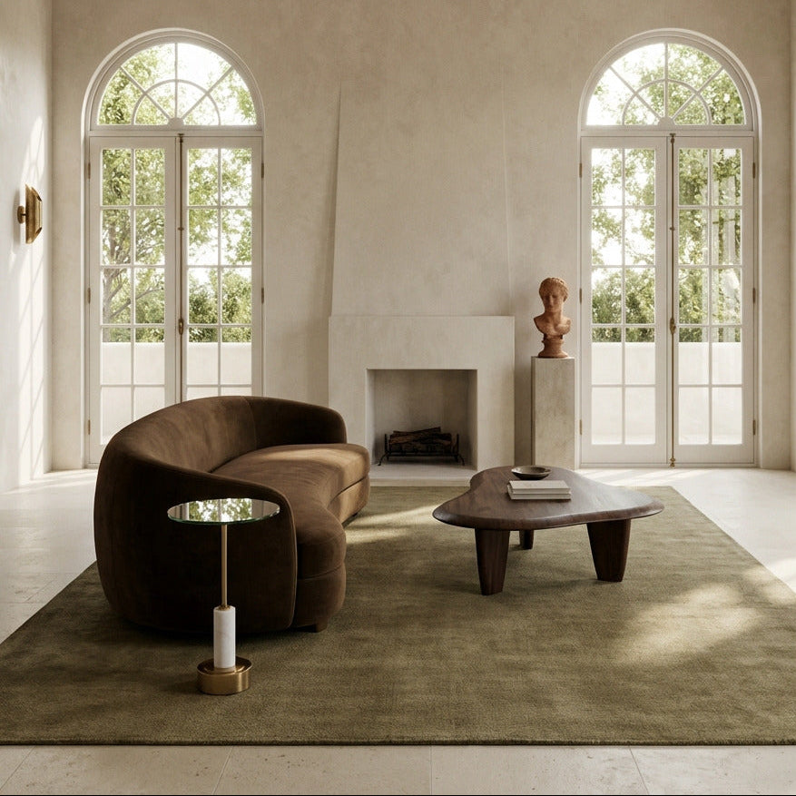 Modern living room with a brown sofa, coffee table, and decorative items.