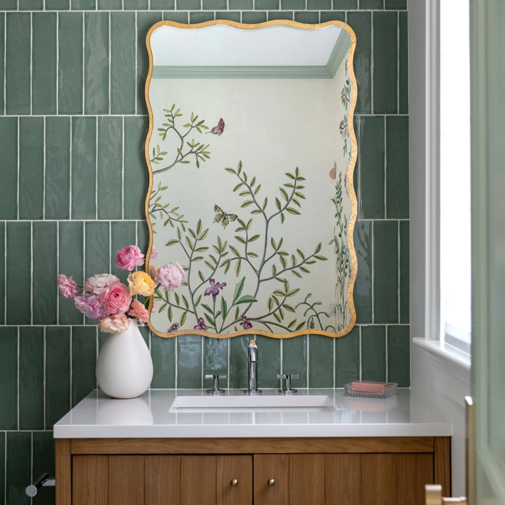 Gold scalloped mirror in green bathroom.