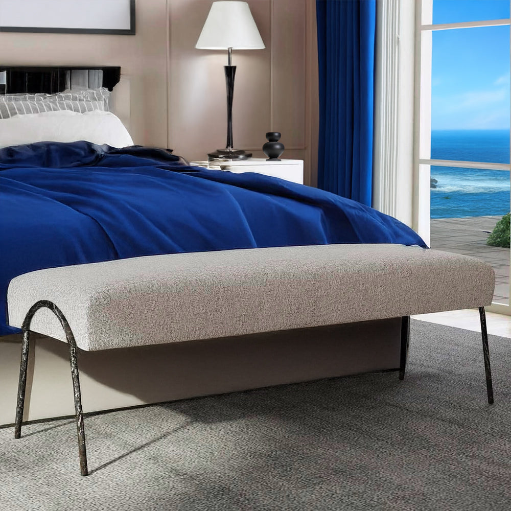 Gray bedroom bench at foot of bed with ocean view. 