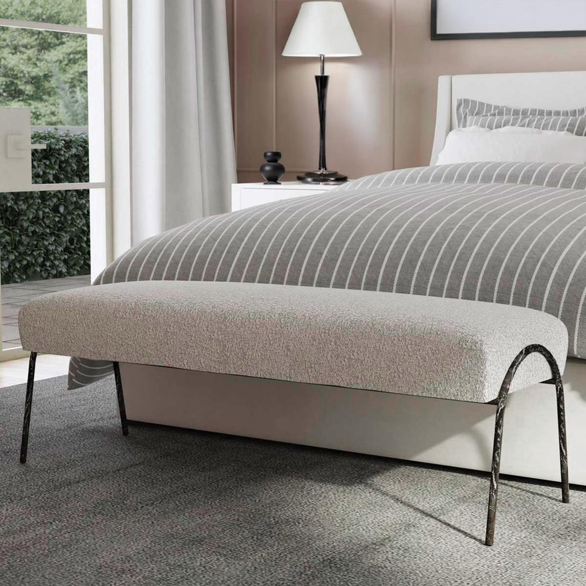 Gray boucle bench with iron legs in front of a chic white and gray bed with a neutral rug.