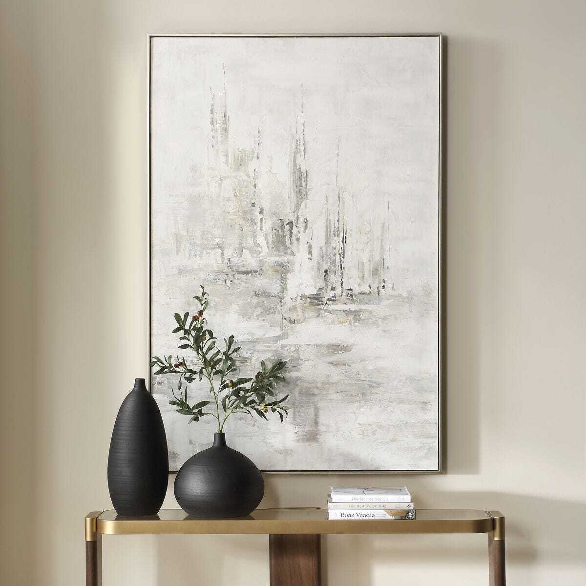 Abstract painting on a wall above a console table with decorative items.