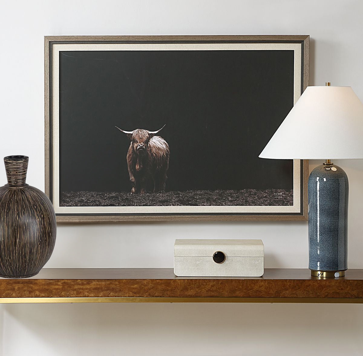 Framed Highland Cow Wall Art in Silver Frame above a console with decorative accessories and a white wall