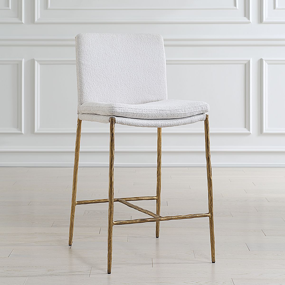 Sleek white boucle counter steel with aged gold metal frame set against a counter.