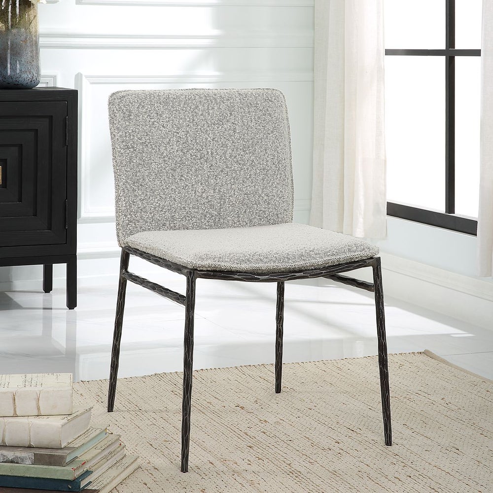 Featuring a curved silhouette, chiseled iron frame, and luxurious boucle fabric.