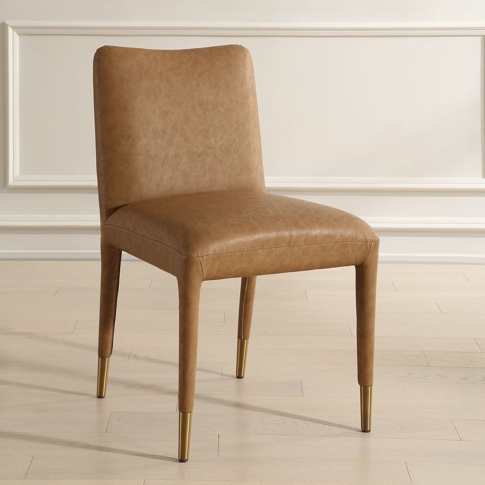 Stylish and contemporary camel faux leather dining chair with brushed brass ferrules. 