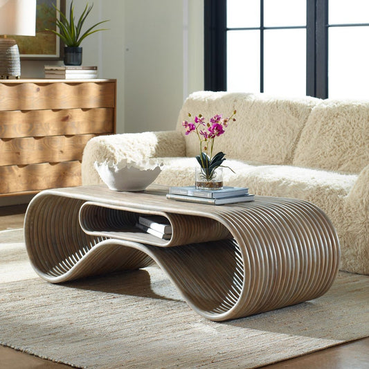 This coffee table is  functional art, crafted entirely from white-washed rattan poles. Its soft, undulating curves create a sense of visual lightness while offering practical storage solutions.