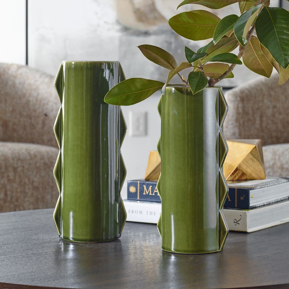 Set of  two Green zig-zag contemporary modern ceramic vases, on a table with books behind them.