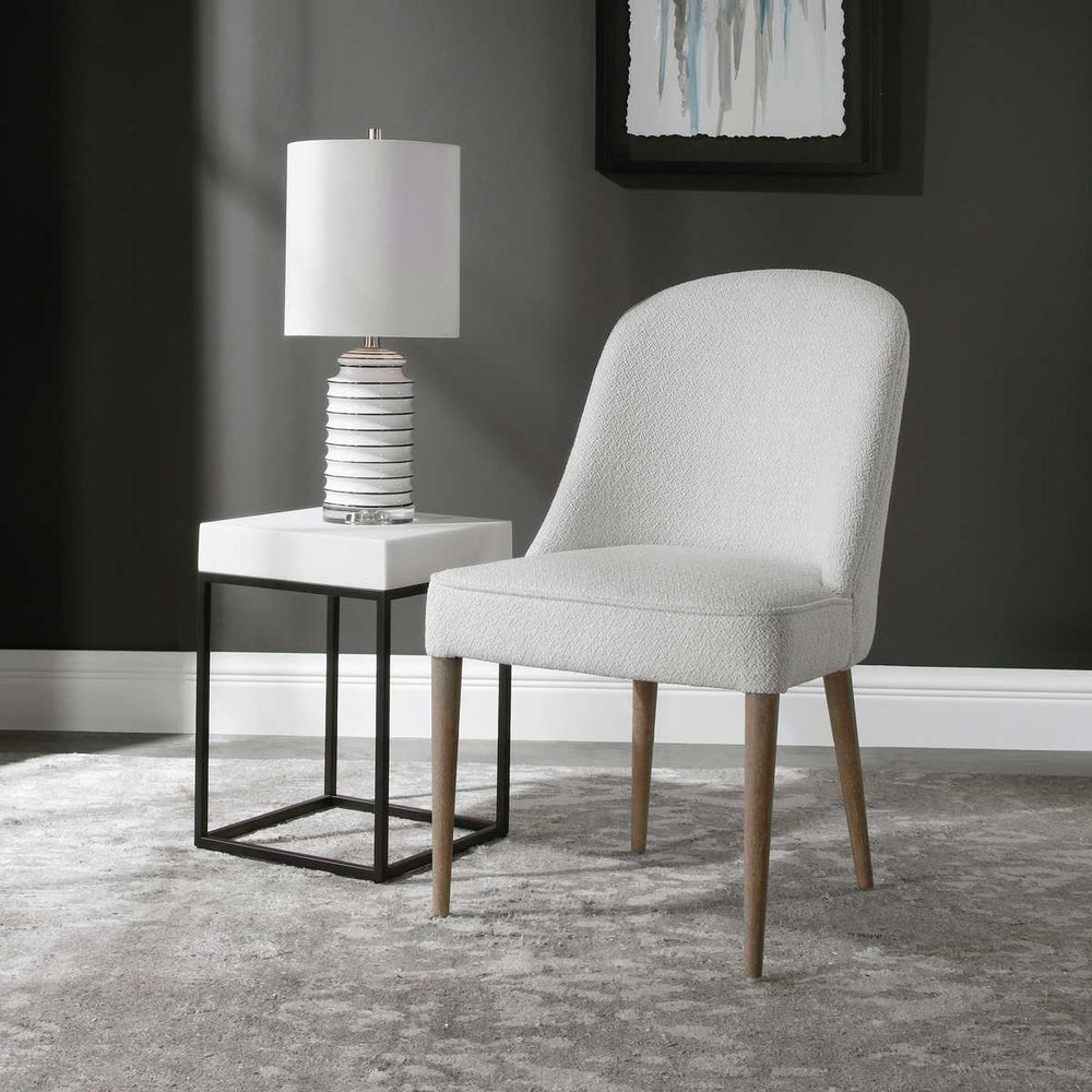 A perfect modern dining chair featuring a casual off-white textured fabric, welted trim, and light walnut solid wood legs.