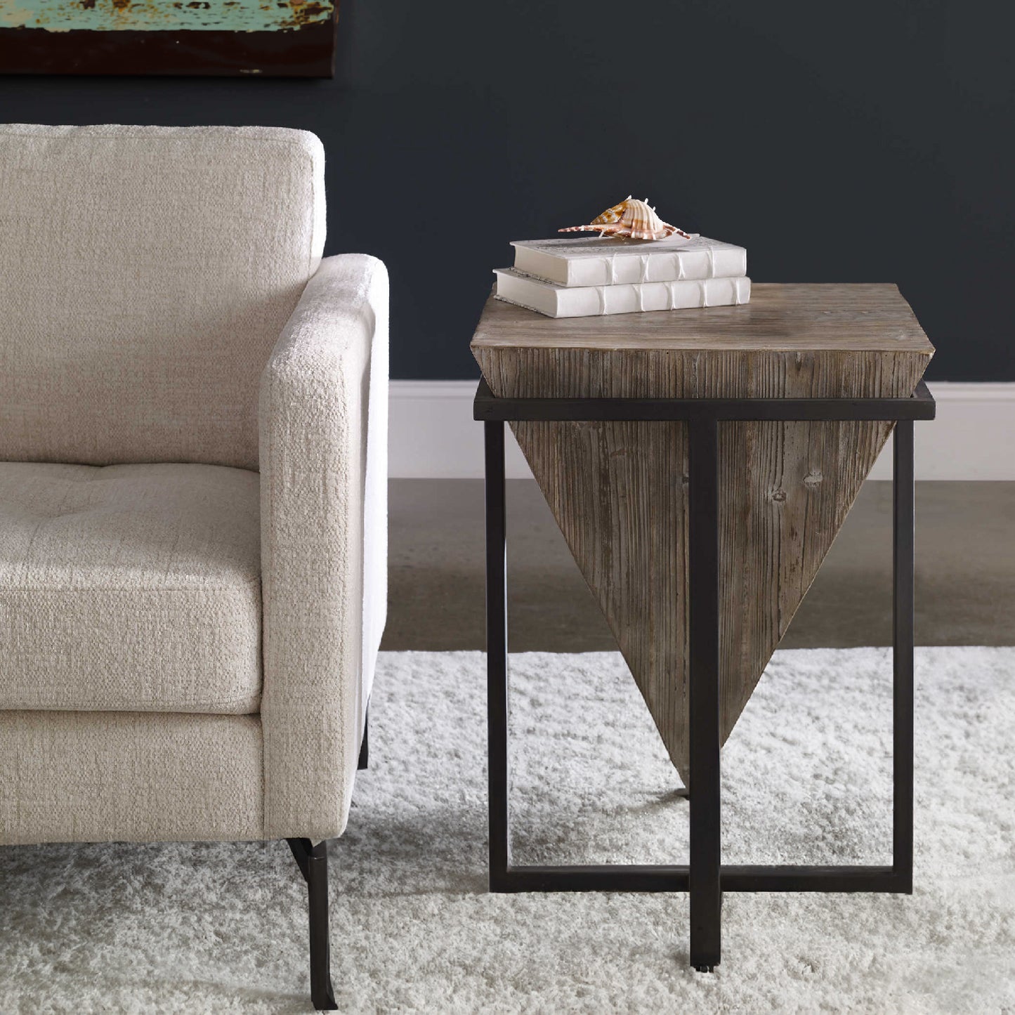 Industrial end table with white wool rug and decorative white chair.