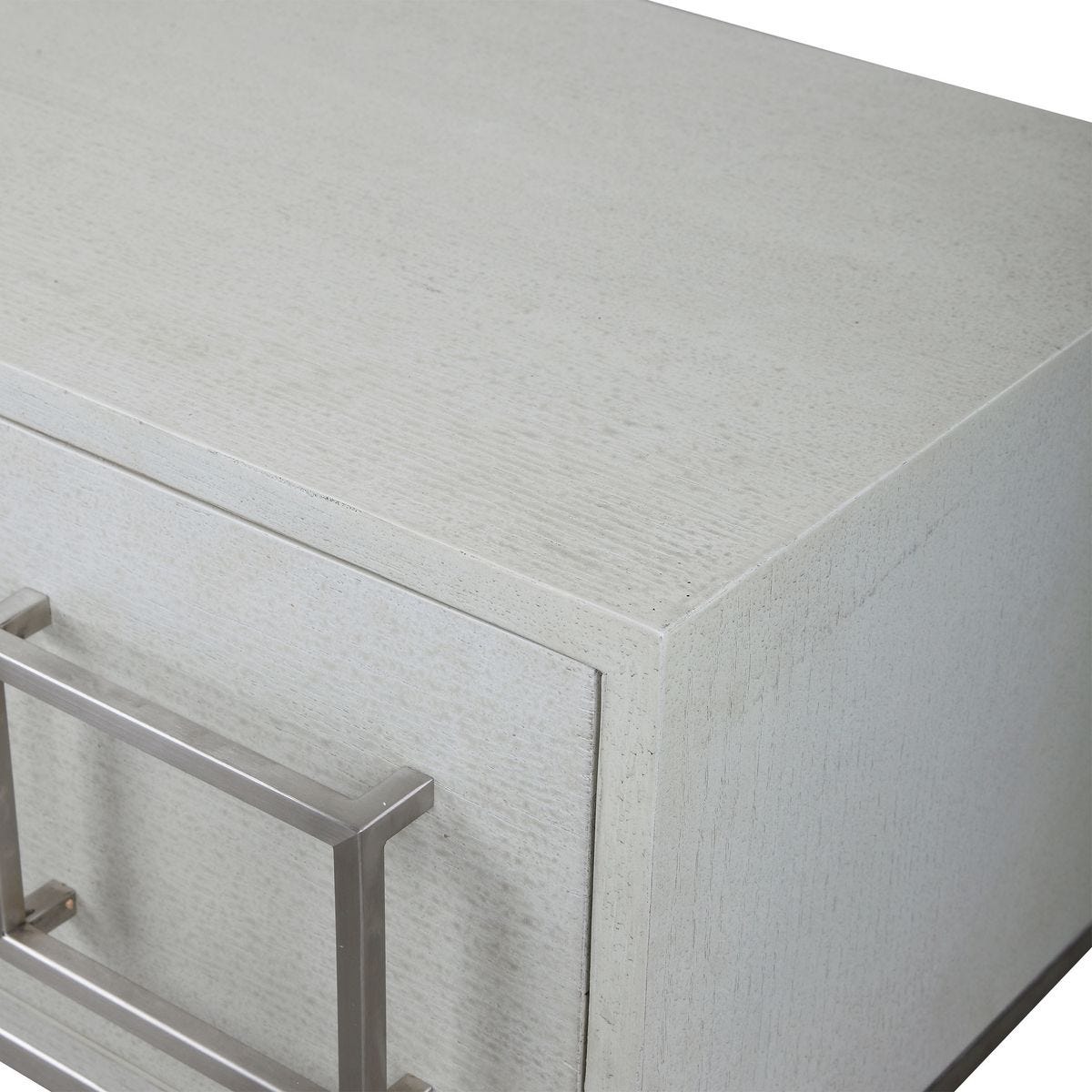Close-up of a textured white cabinet with a metal handle on a white background