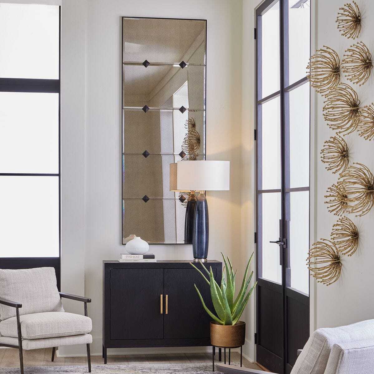 Modern interior design with a black cabinet, mirror, and decorative elements.