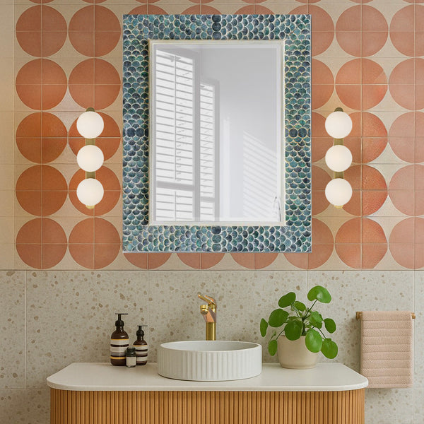 Mermaid mirror in orange tile bathroom.