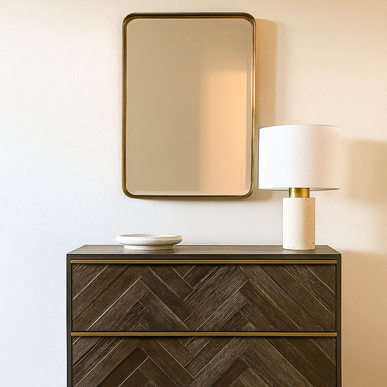 Nighstand with chevron pattern, lamp, and mirror in a room setting