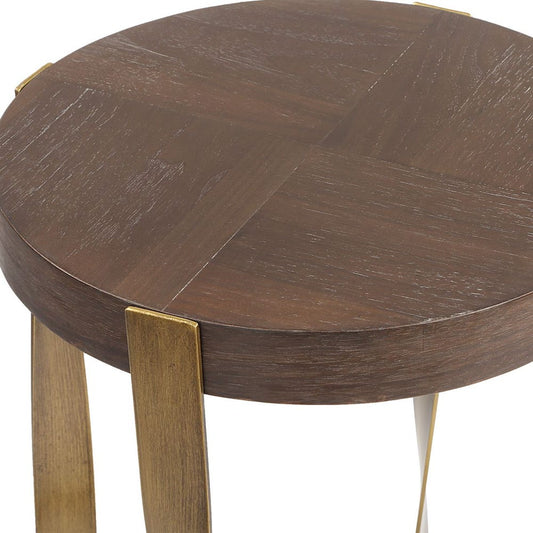 Bronze side table with a plant next to a brown armchair in a room.