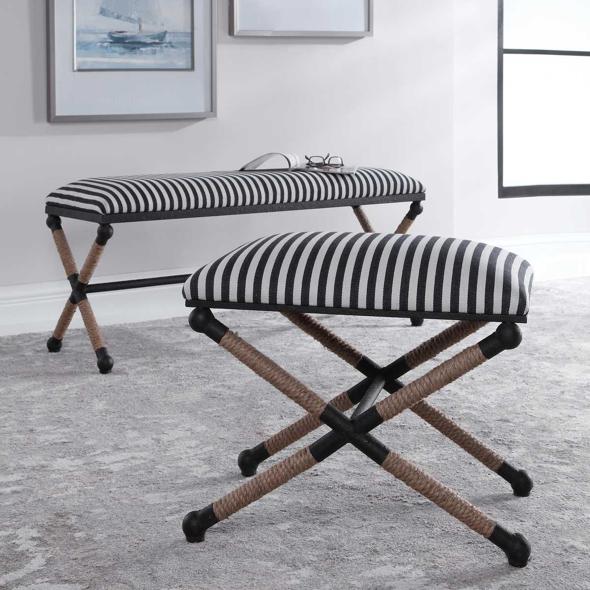 Two striped stools with black and white seats and wooden legs in a room.