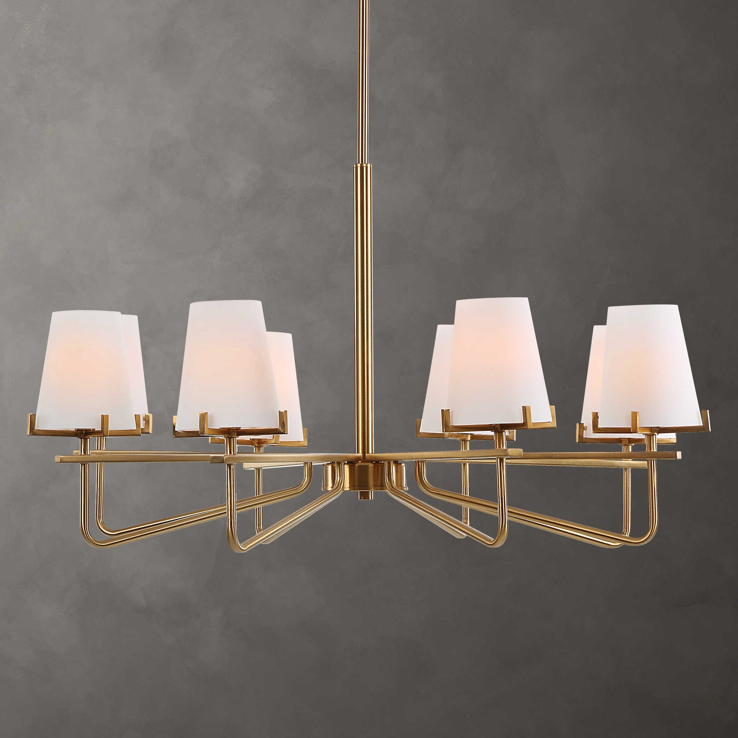 A modern brass finish chandelier with cone shaped shades, designed with graceful accent lines.