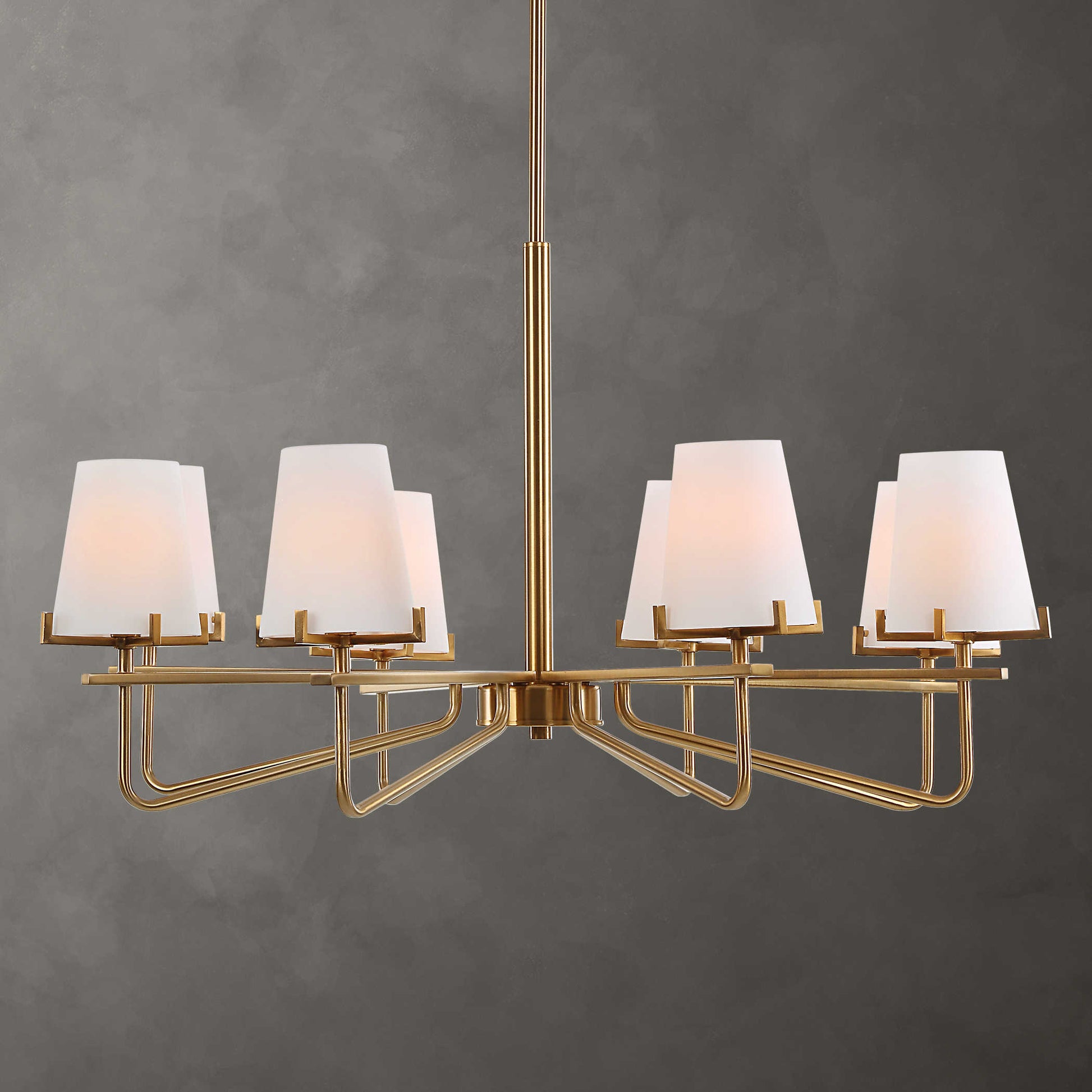 A modern brass finish chandelier with cone shaped shades, designed with graceful accent lines.