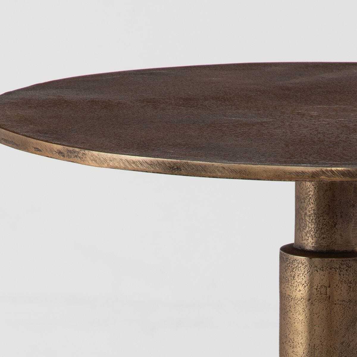 Bronze side table with a round top on a light gray background